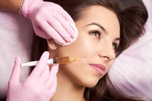 A woman receiving dermal fillers in her cheek