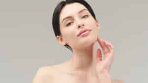A woman touching her cheek after a CO2 laser treatment in Norman, OK