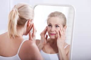 A woman looking in the mirror and considering a facelift in Oklahoma