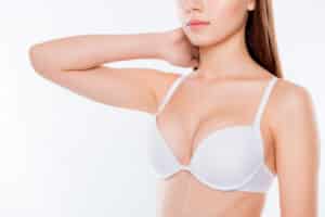 A cropped shot of a woman in a white bra after a breast lift in Oklahoma
