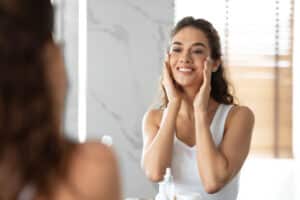 A woman touching her cheeks after a CO2 laser resurfacing treatment in Norman, OK A woman touching her cheeks after a CO2 laser resurfacing treatment in Norman, OK
