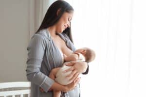 A woman breastfeeding before getting a breast lift in Edmond, OK