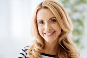 A close-up shot of a doctor marking a woman's eye for blepharoplasty in Norman, OK A woman smiling after an upper lip lift in Norman, OK